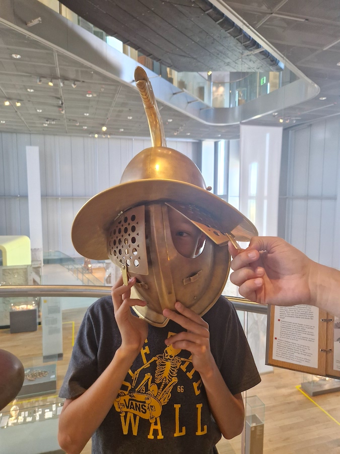 Meine Güte, wie schwer ist das!? Sohnemann testet einen römischen Helm (Foto: Pelzer)
