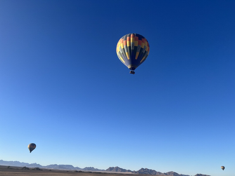 Auf dem Weg zum Sossusvlei seht Ihr Heißluftballone, mit denen Ihr auch über die Wüste fliegen könnt